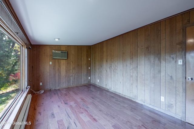 1258 Hawthorn Rd, Niskayuna, NY 12309 - spare room with wood finished floors, wood walls, a wall unit AC, and a baseboard heating unit