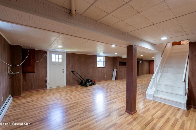 1258 Hawthorn Rd, Niskayuna, NY 12309 - below grade area featuring baseboard heating, light wood-style floors, wooden walls, and stairs