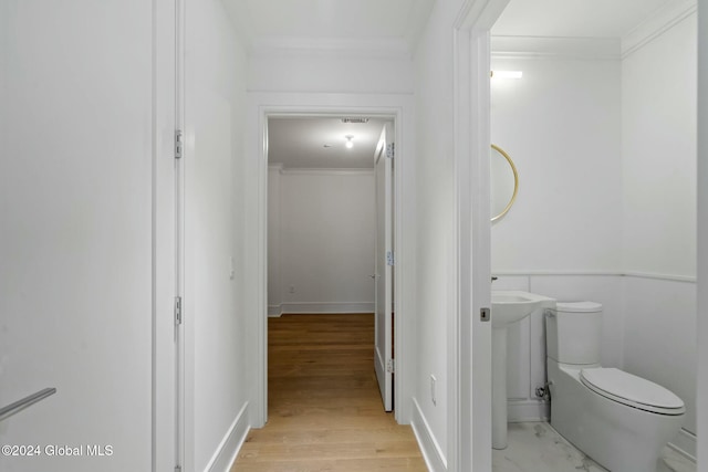 bathroom featuring toilet, crown molding, and wood finished floors