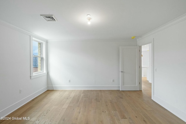 unfurnished room featuring light wood-style flooring, baseboards, visible vents, and ornamental molding