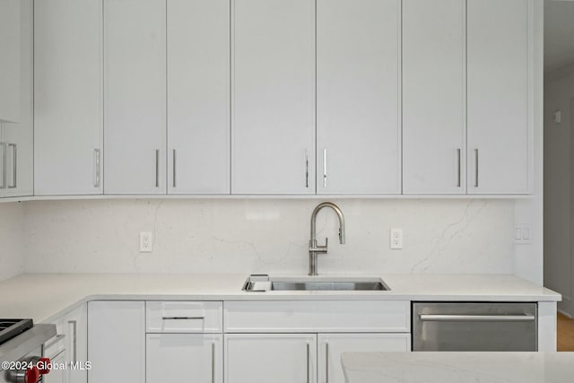 kitchen with white cabinetry, a sink, stove, dishwasher, and tasteful backsplash