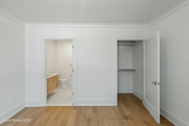 unfurnished bedroom featuring a closet, light wood finished floors, and ornamental molding