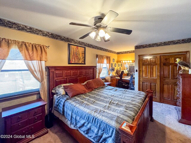 carpeted bedroom with multiple windows, ceiling fan, and a closet