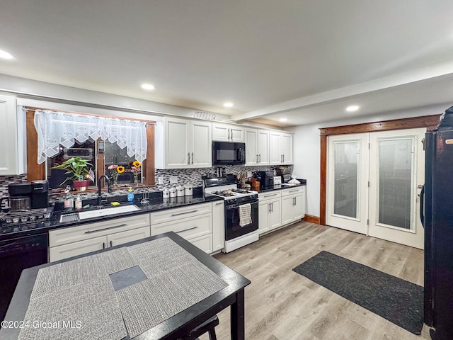 kitchen with white cabinetry, sink, light hardwood / wood-style flooring, decorative backsplash, and black appliances