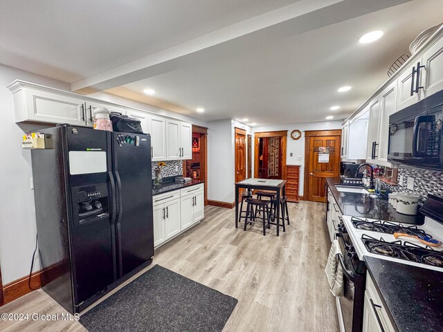 kitchen featuring black appliances, white cabinets, and backsplash