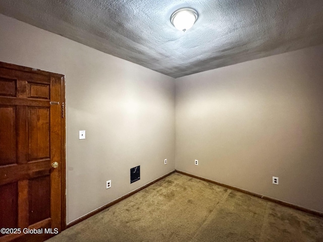 carpeted spare room with a textured ceiling