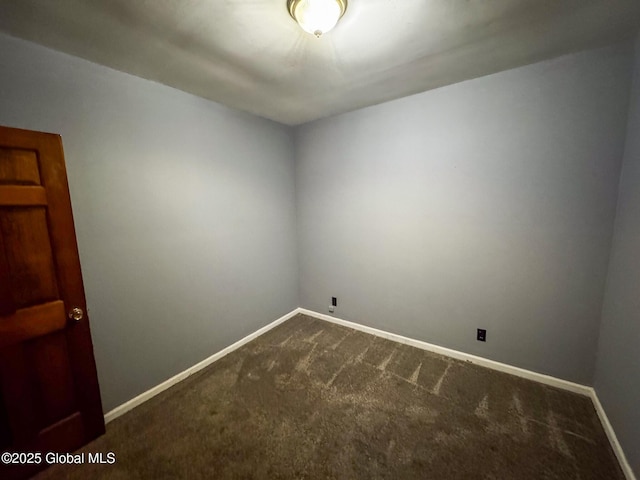 unfurnished room featuring dark carpet