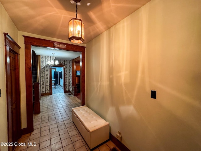 corridor featuring a notable chandelier and light tile patterned flooring