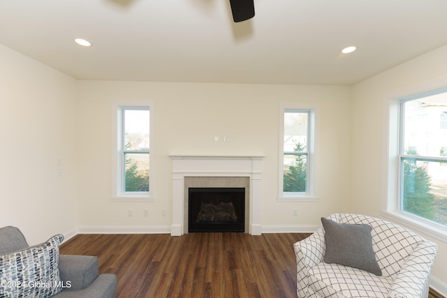 living room with a tile fireplace, ceiling fan, and dark hardwood / wood-style flooring