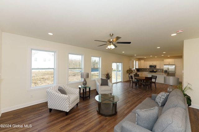 living room featuring dark wood-type flooring and ceiling fan