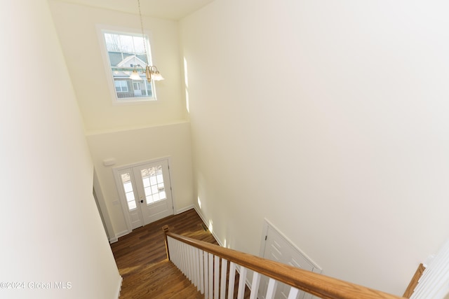 entryway featuring dark hardwood / wood-style flooring, a notable chandelier, and a high ceiling