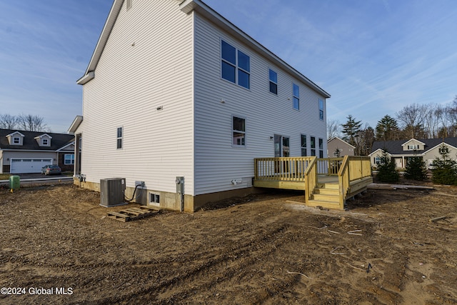 rear view of house featuring cooling unit and a wooden deck