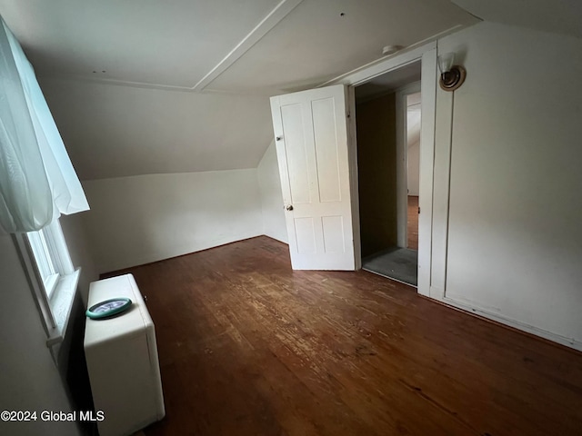 additional living space with dark wood-type flooring and lofted ceiling