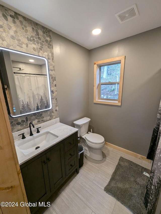 bathroom featuring vanity, toilet, and a shower with shower curtain