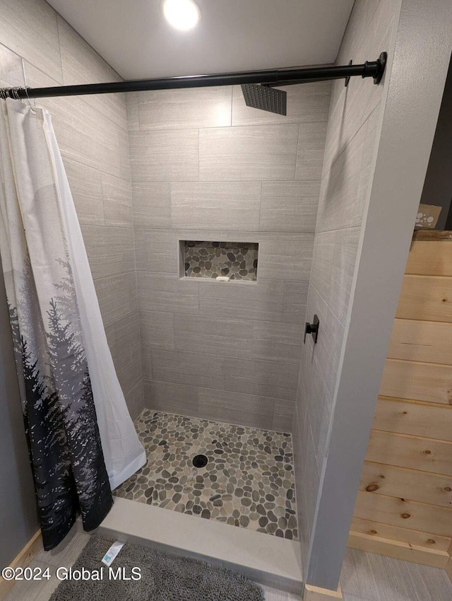 bathroom featuring a shower with shower curtain and hardwood / wood-style flooring