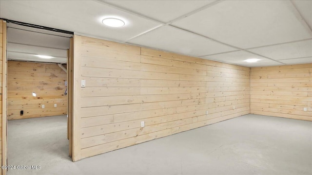 basement featuring wood walls