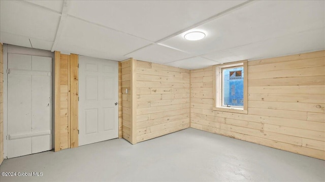 basement featuring wood walls