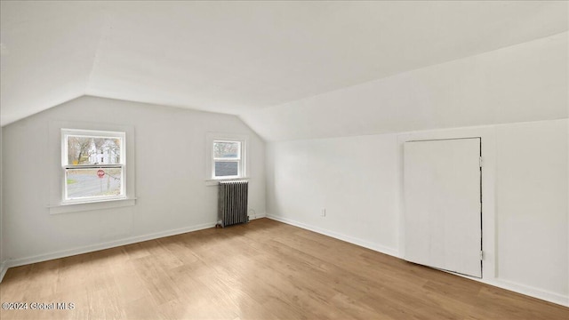 bonus room featuring radiator, lofted ceiling, and light hardwood / wood-style floors