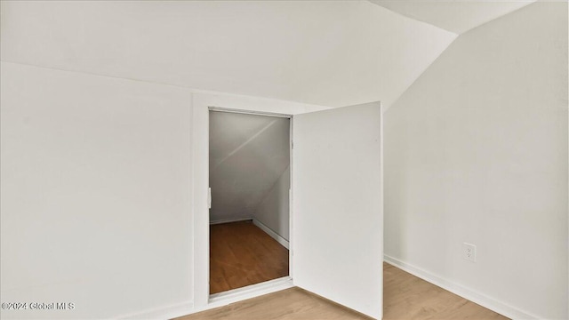 interior space with light wood-type flooring and lofted ceiling