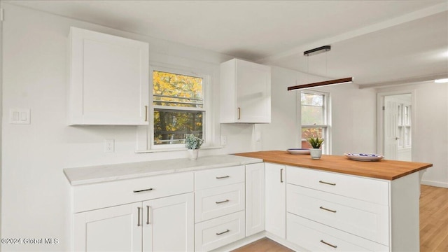 kitchen featuring white cabinets, a wealth of natural light, and light hardwood / wood-style flooring