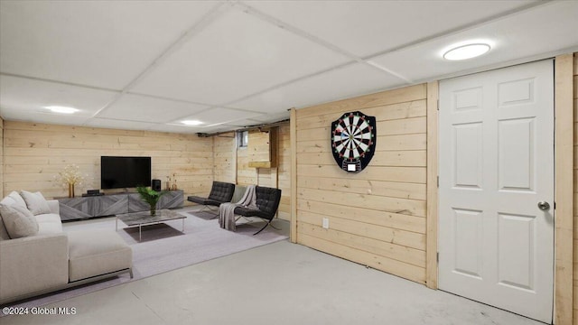 living room with concrete flooring and wood walls