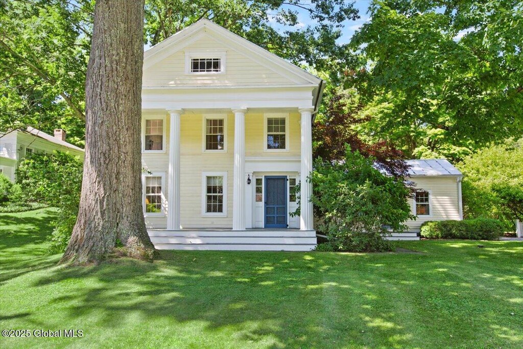 greek revival inspired property with a front yard