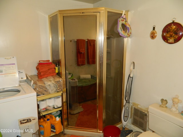 bathroom featuring washer / dryer, toilet, and walk in shower