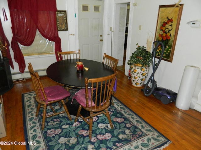 dining area featuring baseboard heating and hardwood / wood-style floors