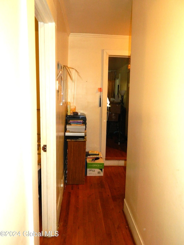 hall with dark wood-type flooring and crown molding