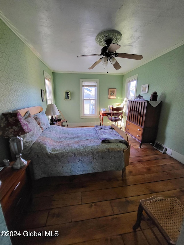 bedroom featuring ceiling fan, multiple windows, dark hardwood / wood-style flooring, and ornamental molding