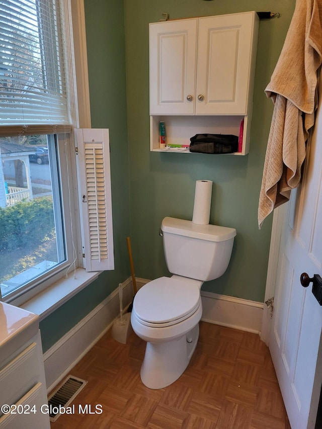 bathroom with vanity, parquet floors, and toilet