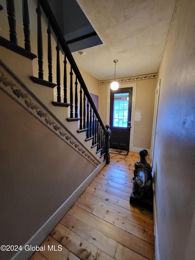 foyer entrance with wood-type flooring and a textured ceiling