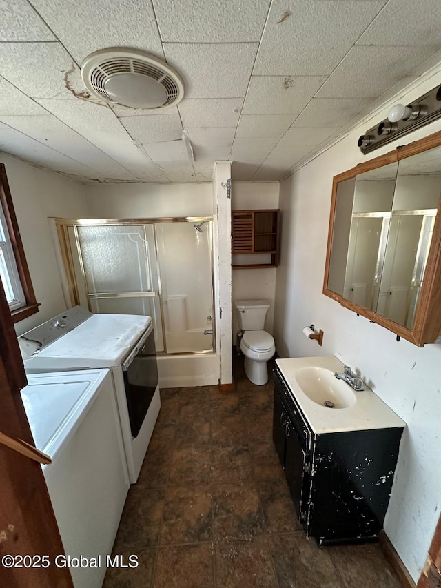 bathroom featuring an enclosed shower, vanity, toilet, and washer and clothes dryer