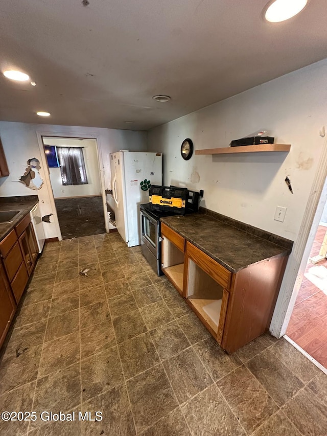 kitchen with white refrigerator with ice dispenser, sink, and stainless steel range with electric stovetop