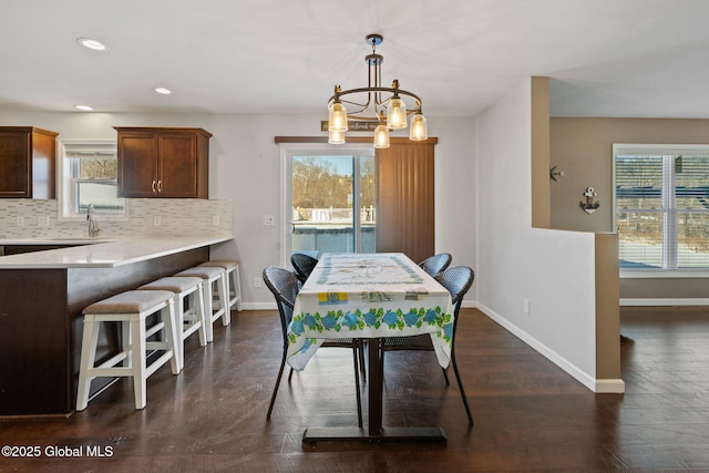 dining room featuring dark wood-type flooring, a chandelier, and sink