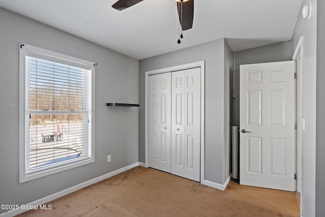 unfurnished bedroom featuring light colored carpet, ceiling fan, and a closet