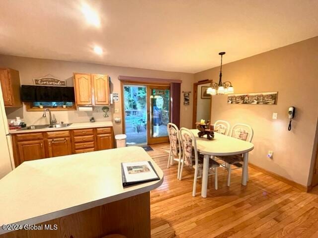 kitchen featuring a chandelier, light hardwood / wood-style floors, sink, and decorative light fixtures