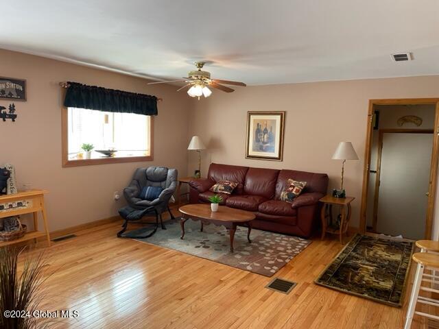 living room with light hardwood / wood-style floors and ceiling fan