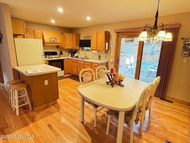 kitchen featuring decorative light fixtures, white appliances, sink, a chandelier, and light hardwood / wood-style flooring