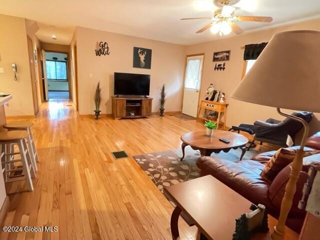 living room featuring light hardwood / wood-style floors and ceiling fan