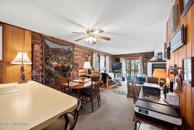 dining room with a textured ceiling, carpet floors, ceiling fan, and wooden walls