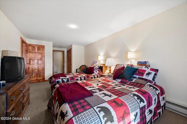 bedroom featuring a textured ceiling, dark carpet, and a baseboard heating unit