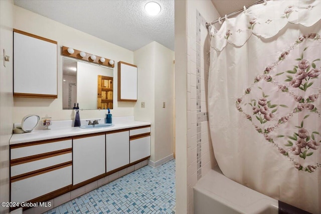 bathroom featuring tile patterned floors, shower / tub combo, vanity, and a textured ceiling