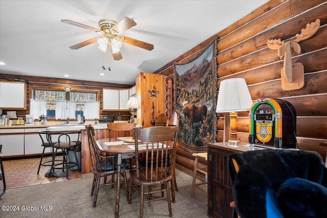 dining room with ceiling fan, light colored carpet, and a textured ceiling