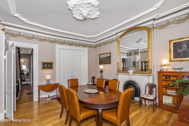 dining space featuring light hardwood / wood-style floors and ornamental molding