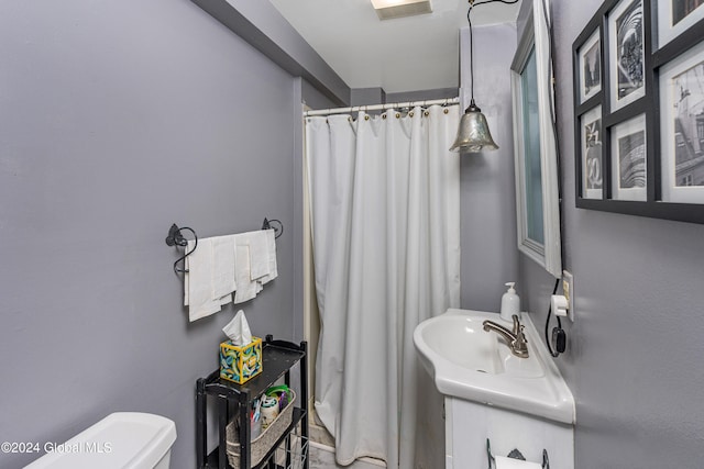 bathroom featuring vanity, toilet, and curtained shower