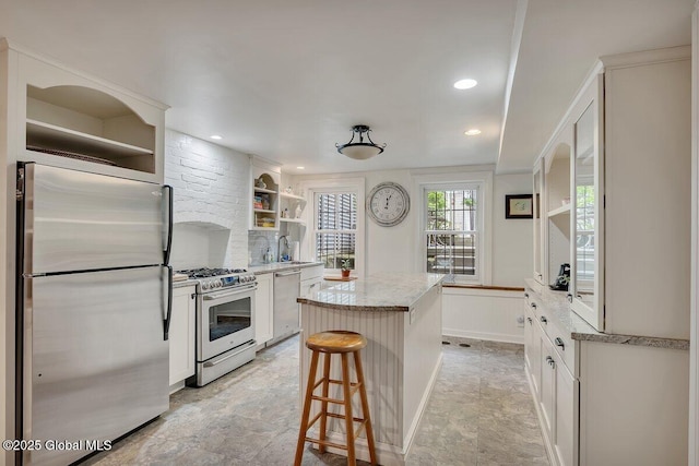 49A Dove St, Albany, NY 12210 - kitchen with appliances with stainless steel finishes, open shelves, a kitchen island, a sink, and white cabinets