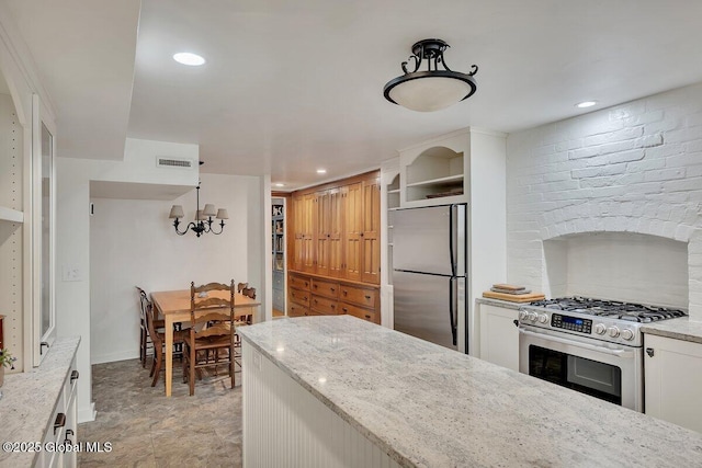 49A Dove St, Albany, NY 12210 - kitchen with stainless steel appliances, light stone counters, white cabinetry, recessed lighting, and a chandelier