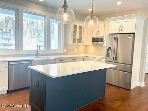 kitchen with pendant lighting, white cabinets, a center island, and stainless steel appliances