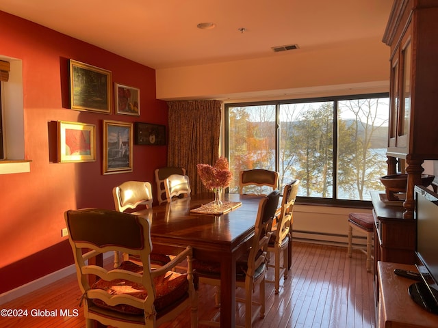 dining room with hardwood / wood-style flooring and a baseboard heating unit